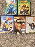 Front view of five DVD cases showing cover art for Rio 2, Madagascar, Rio, 10 Movie Pack Westerns, Brewster’s Millions