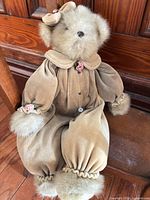 Full view of beige plush bear in tan velvet romper
