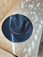 Top view of black felt cowboy hat showing brim and leather hatband
