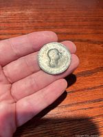 Obverse view of worn coin in hand