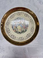 Front of plate showing courting scene, scroll border, and gold rim