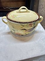 Stoneware soup tureen with lid on, bird and floral design visible