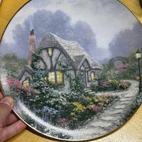 Front view of plate showing cottage artwork and gold rim