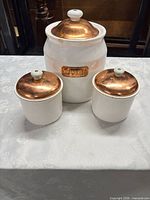 front view of three canisters showing sizes and lids