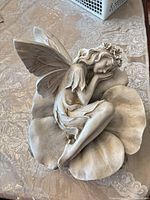 Full view of fairy statue on flower