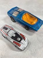 Top view of both die-cast cars showing colors, graphics and overall wear