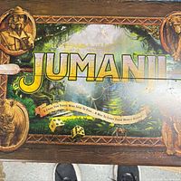 Closed wooden Jumanji box top showing logo and jungle artwork