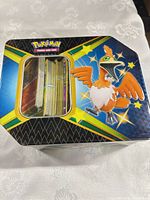 Top view of Pokemon tin showing stack of cards inside