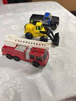 All three vehicles in a line: fire truck, front loader, pickup