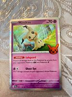 Front of Mimikyu card with Safeguard & Ghost Eye