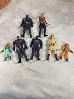 All seven action figures arranged on fabric background