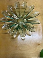 Overhead view of green flower-shaped glass bowl showing petaled rim and central well