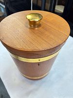 lid with brass knob showing wood grain and brass band