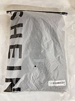 Front of sealed SHEIN polybag containing dress