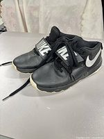 Three-quarter view of both shoes showing uppers, strap, laces, swoosh logo