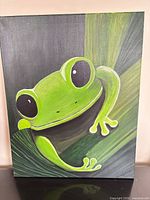 Front view of acrylic painting featuring green frog, shows subject, colors, and artist signature on gallery-wrapped canvas