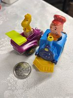 Top view showing both Peanuts push cars with coin for scale
