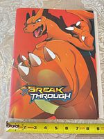 Front cover of Charizard Break Through binder with measurement scale