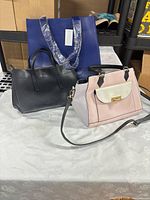 All three handbags displayed on table
