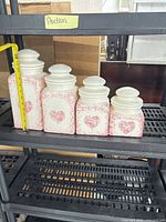 Four ceramic heart motif jars on shelf