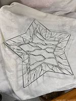 full view of star-shaped chrome bowl on fabric