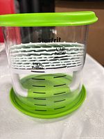 Clear storage cylinder showing Starfrit branding and patty size markings