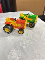 Both toy tractors side by side on table