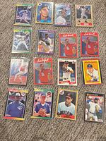 Loose assortment of baseball cards laid out on carpet, first set of 16