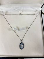 Full necklace laid flat in box showing pendant and chain with clasp