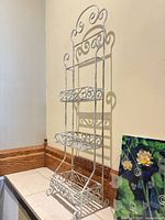 Full view of white metal 3-tier étagère against wall