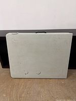 Table folded in carry position showing handle and overall appearance