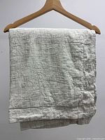 Folded pillow sham showing crinkled cotton texture on hanger