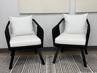 Front view of both black corded patio chairs with white cushions