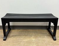 Full view of black wood slat bench front