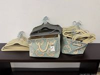 lot overview: hangers sorted by color resting in two patterned fabric bins on shelf