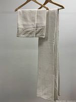 Folded pillow sham and portion of duvet on hangers