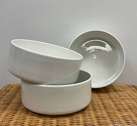 Three white ceramic bowls stacked to show quantity and design