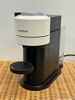 Front view of Nespresso Vertuo Next machine showing off-white brew head and drip tray