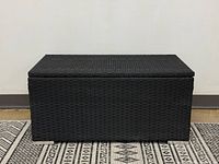 Closed black resin wicker storage bench front view