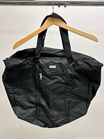 Front view showing brand badge, front zip pocket, handles