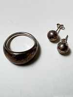 ring and pair of earrings on flat surface