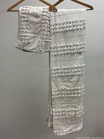 Duvet cover folded over hanger with sham on top, showing popcorn stitch texture