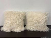 Front view of both white Mongolian lamb wool pillows