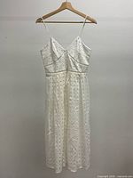 Front view of white cotton eyelet dress on hanger