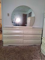 Front view of 6-drawer dresser with round mirror