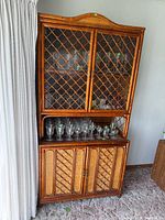 Full view of hutch with glass lattice doors and glasses on shelf