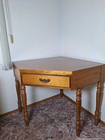 Corner desk front view showing drawer and turned legs