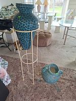 Tall mosaic vase in metal stand with smaller pot beside