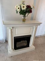 Front view of fireplace mantle with insert and vase on top