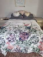 Full view of double bed with floral comforter and pillows